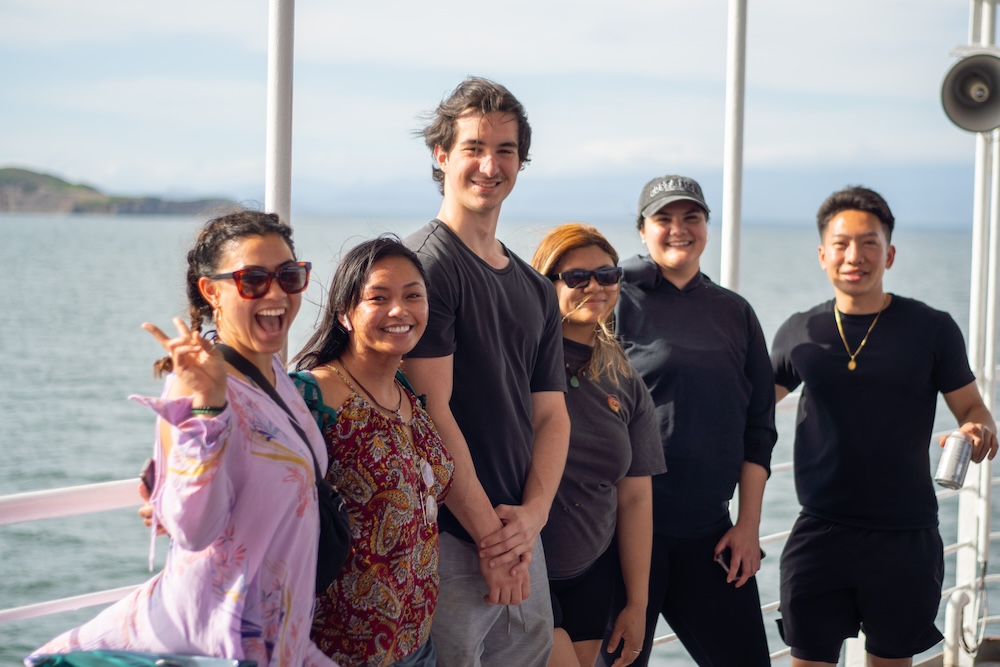 Group of students posing for picture by the water