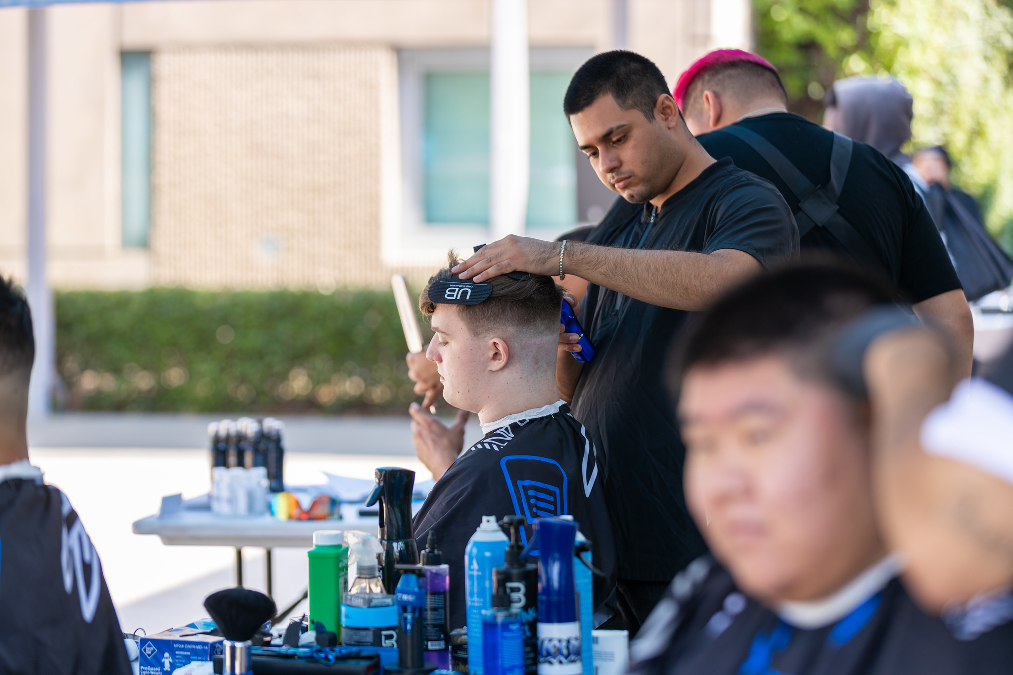 Student getting haircut at basic needs fair