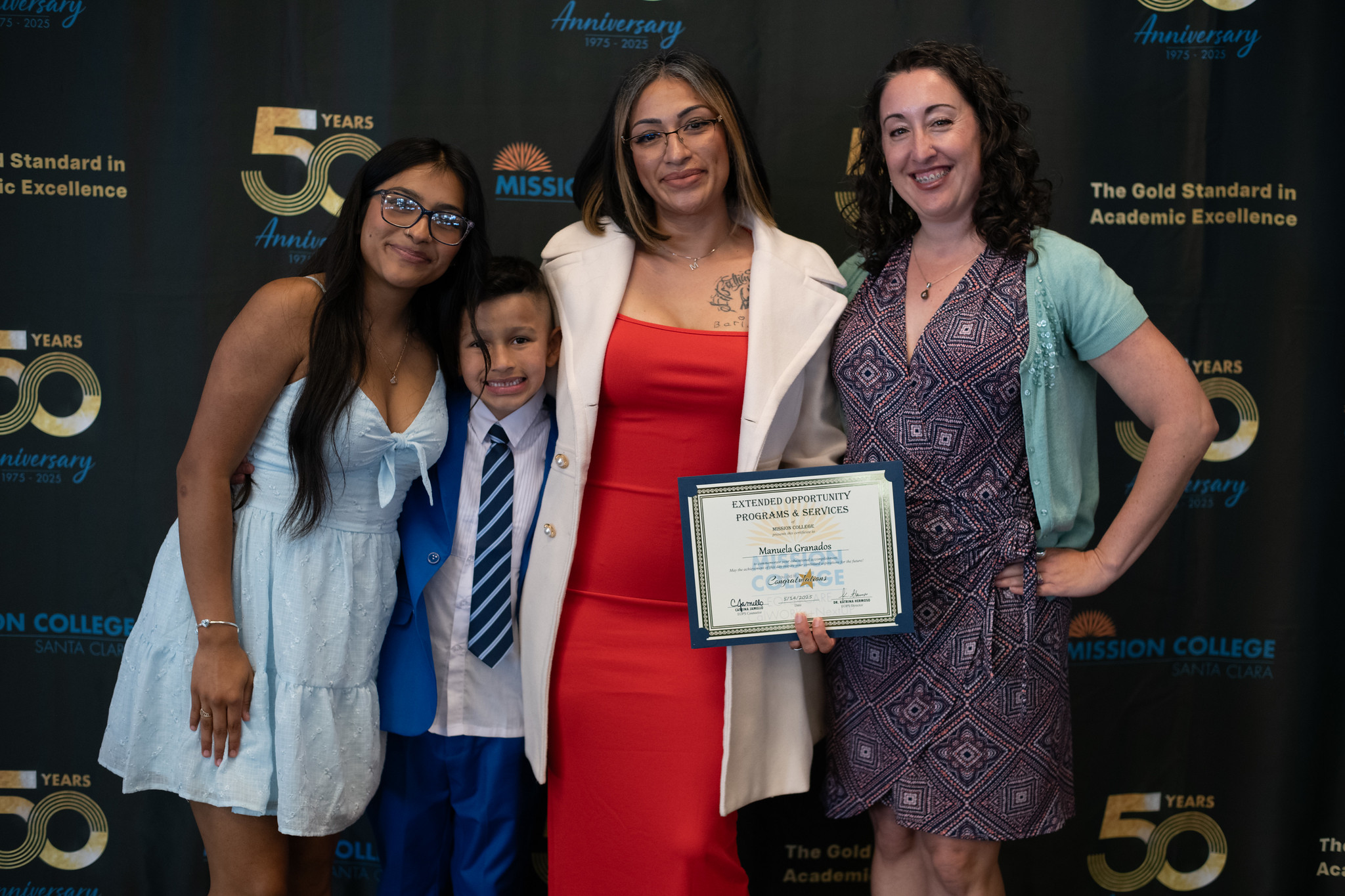 Student holding certificate with others