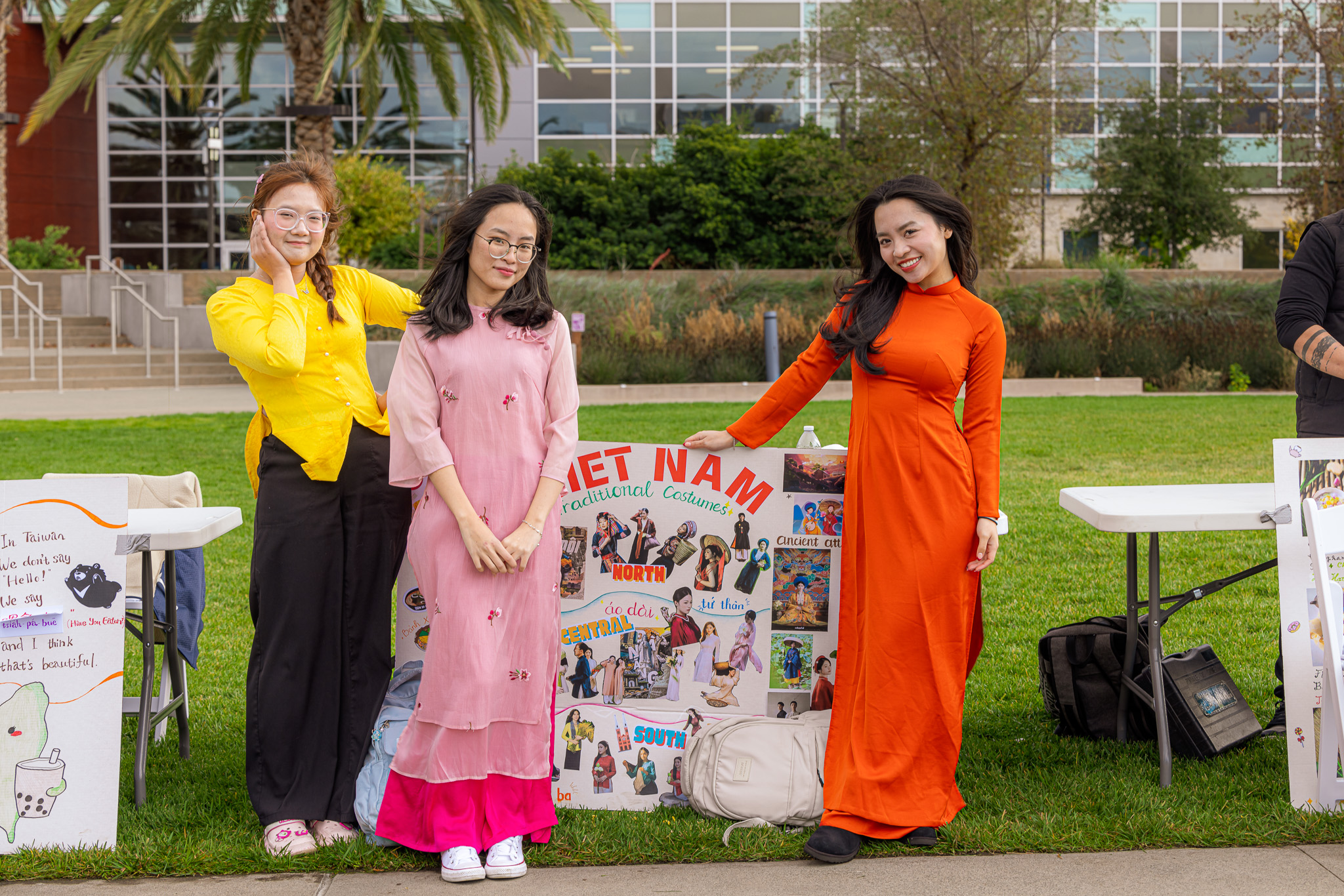 Students posing for picture in front of their poster about Vietnam