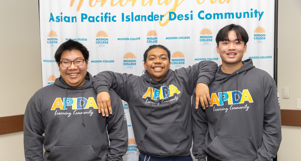Students smiling near banner