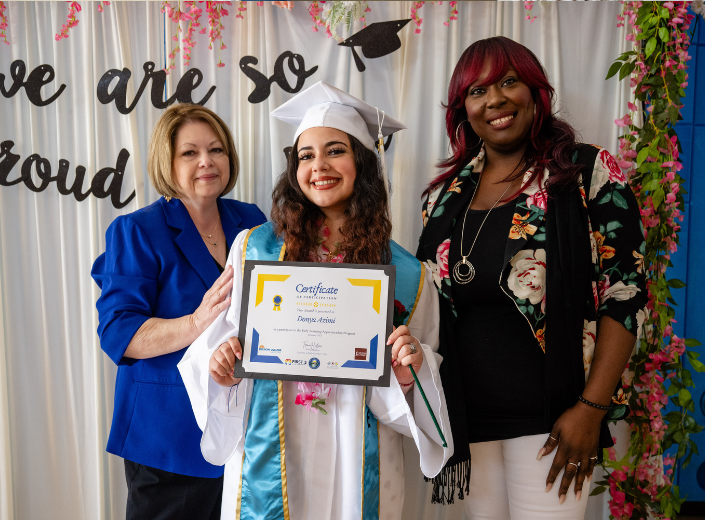 Smiling graduate and teachers at event
